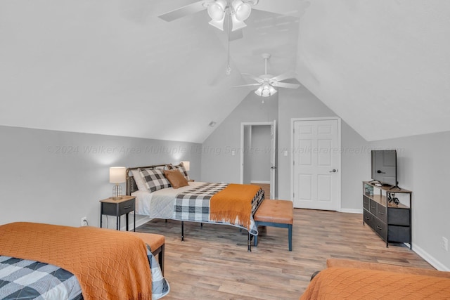 bedroom with ceiling fan, vaulted ceiling, and light hardwood / wood-style flooring