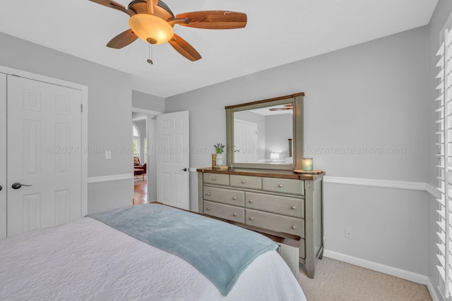 carpeted bedroom with ceiling fan and a closet