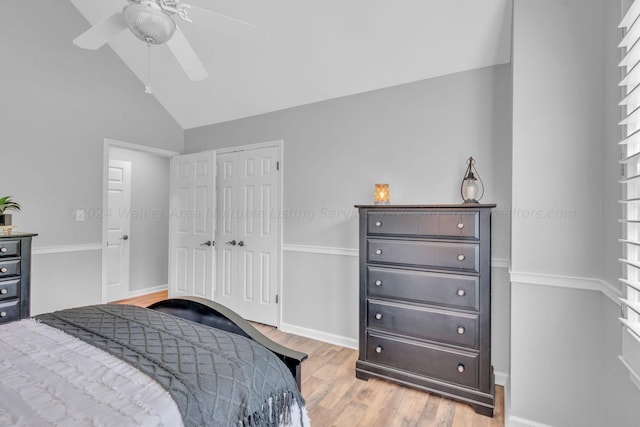 bedroom with a closet, ceiling fan, light hardwood / wood-style flooring, and vaulted ceiling