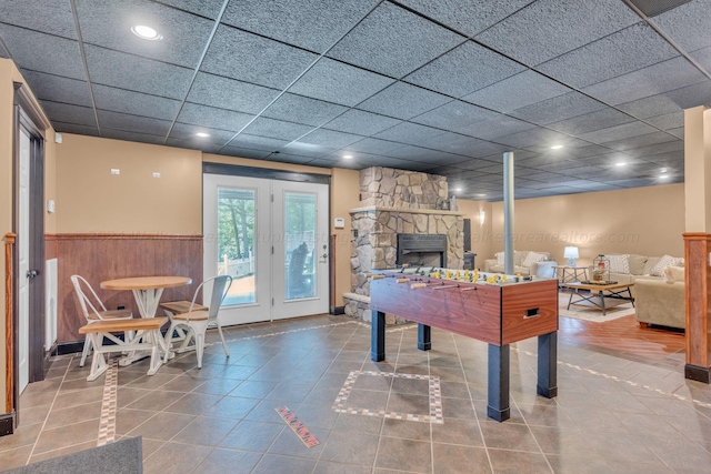 recreation room with a fireplace and tile patterned flooring