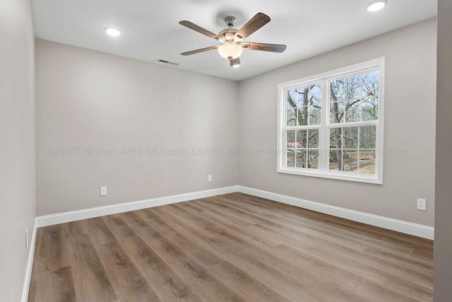 spare room with visible vents, recessed lighting, ceiling fan, wood finished floors, and baseboards