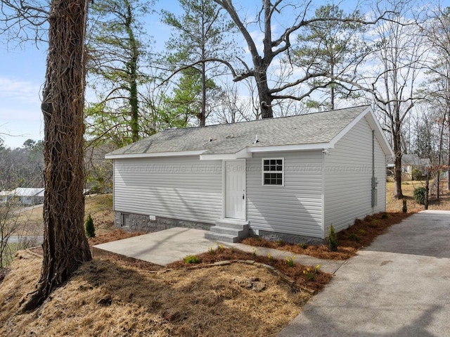 view of front of house with entry steps, a patio, and a shingled roof