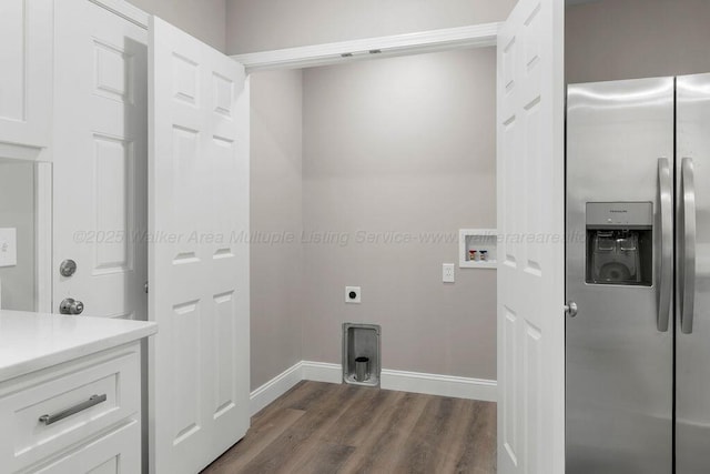 clothes washing area featuring laundry area, baseboards, washer hookup, and dark wood finished floors