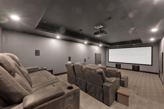 carpeted home theater room featuring a raised ceiling