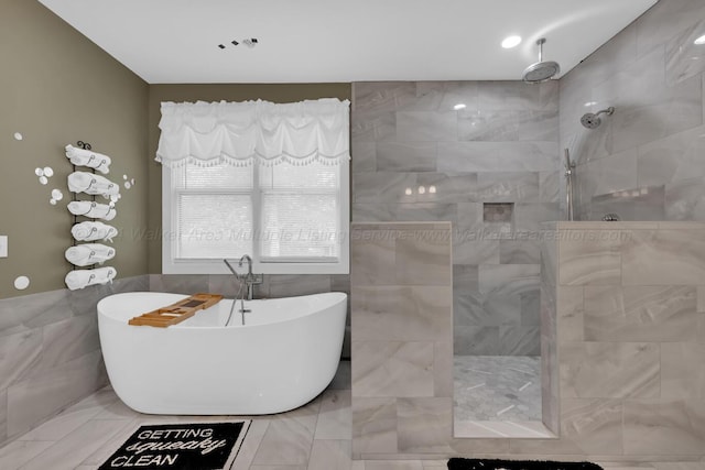 bathroom with tile walls and independent shower and bath