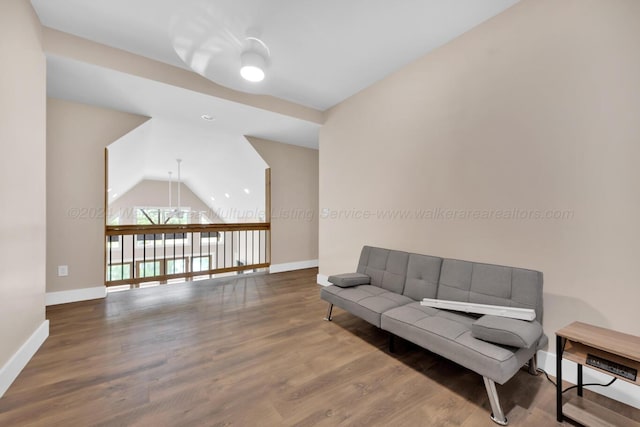 living room featuring wood-type flooring and vaulted ceiling