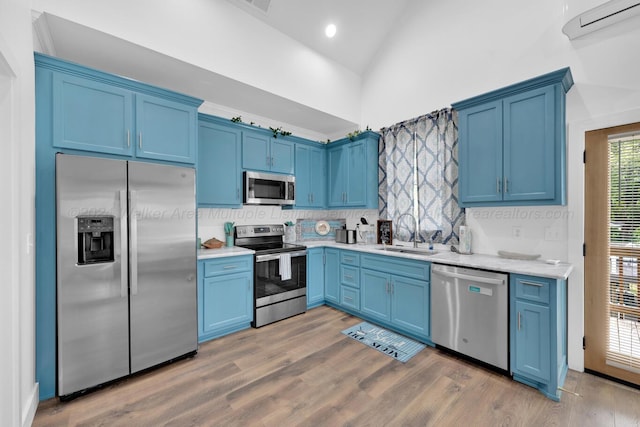 kitchen featuring hardwood / wood-style flooring, blue cabinets, sink, and appliances with stainless steel finishes