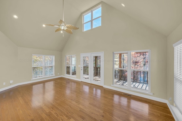 unfurnished living room featuring high vaulted ceiling, light hardwood / wood-style floors, and a wealth of natural light