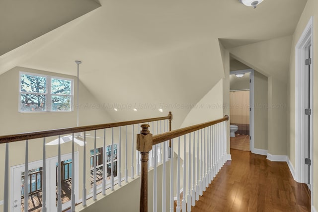 corridor featuring vaulted ceiling and hardwood / wood-style flooring