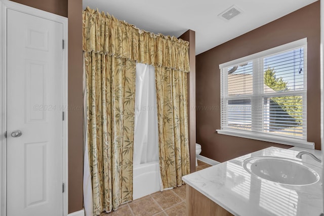 full bathroom featuring tile patterned flooring, vanity, toilet, and shower / bath combo with shower curtain