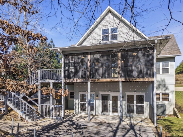 rear view of property featuring a sunroom, central AC, and french doors