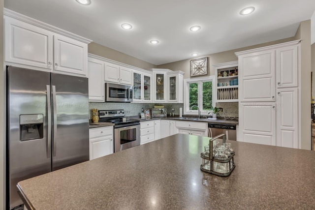 kitchen featuring decorative backsplash, white cabinetry, sink, and appliances with stainless steel finishes