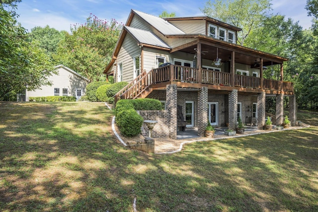 back of property with ceiling fan, a yard, a patio, and a deck