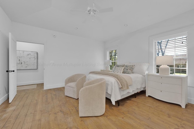 bedroom featuring multiple windows, ceiling fan, and light wood-type flooring