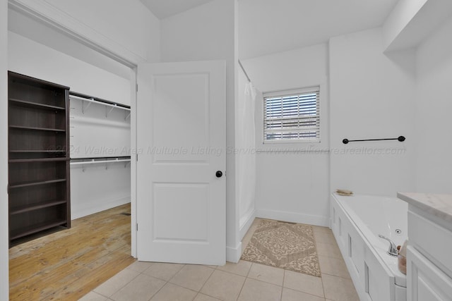 bathroom with tile patterned flooring and a tub