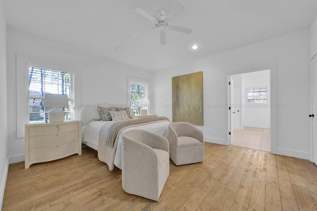 bedroom featuring light wood-type flooring, ensuite bathroom, and ceiling fan