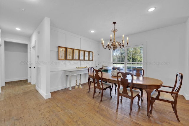 dining space featuring light hardwood / wood-style floors and an inviting chandelier