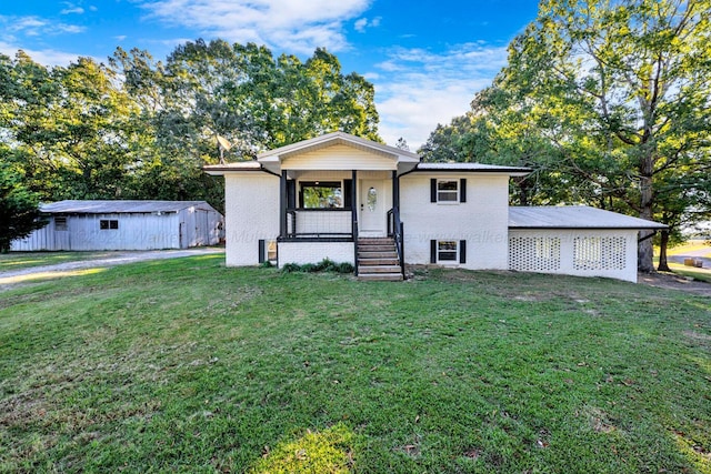 view of front facade with a front yard, an outdoor structure, and covered porch