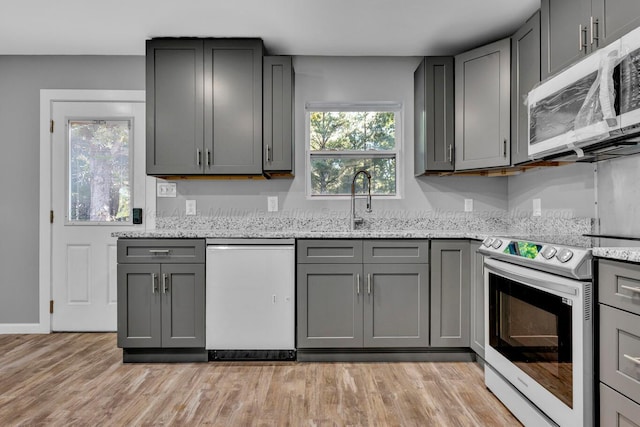 kitchen with appliances with stainless steel finishes, gray cabinets, and plenty of natural light