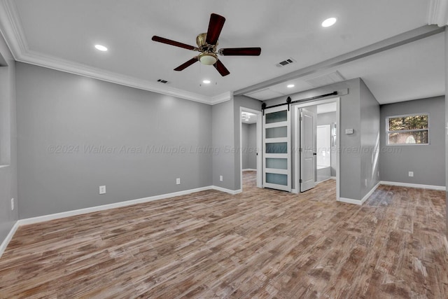 interior space featuring a barn door, light wood-type flooring, and crown molding