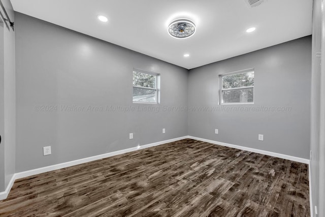 spare room with dark hardwood / wood-style floors and a wealth of natural light