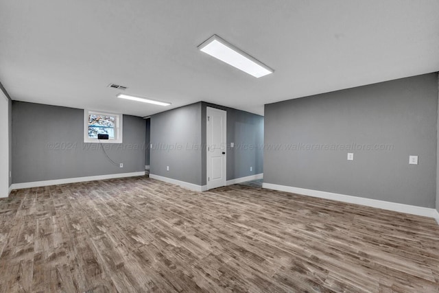 basement with hardwood / wood-style flooring