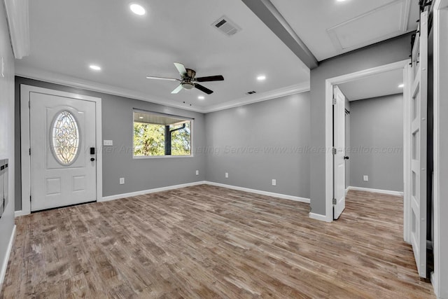 foyer with light wood-type flooring, ceiling fan, and ornamental molding