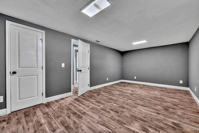 unfurnished room featuring hardwood / wood-style floors and a textured ceiling