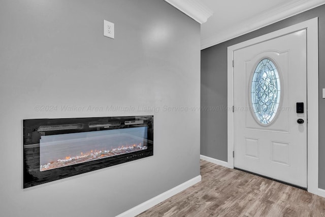 foyer entrance with light wood-type flooring and ornamental molding