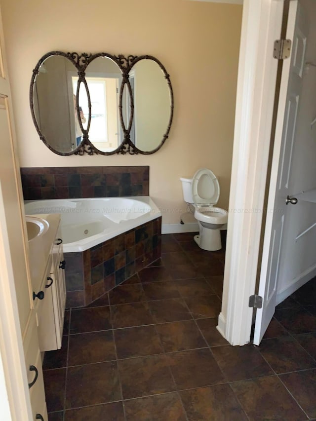 bathroom with vanity, toilet, and tiled tub