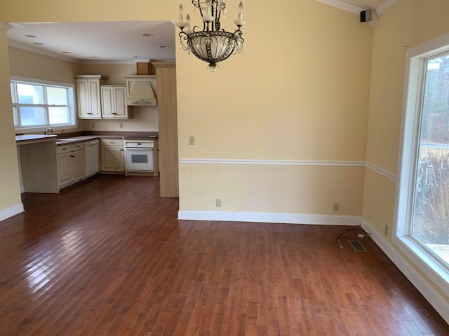 kitchen with crown molding, dark wood-type flooring, white appliances, and an inviting chandelier