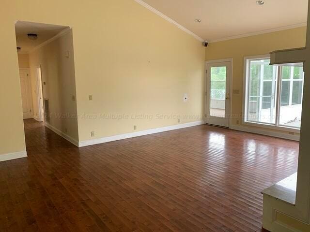 empty room featuring dark hardwood / wood-style flooring and ornamental molding