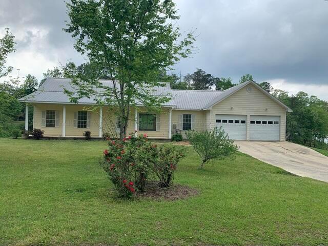 single story home featuring a front yard and a garage