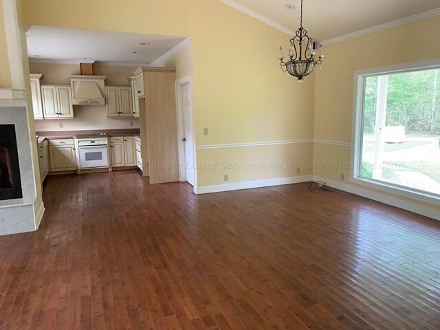 kitchen with white oven, dark hardwood / wood-style flooring, a notable chandelier, premium range hood, and crown molding