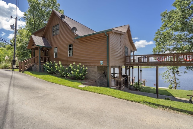 view of home's exterior with a lawn and a water view