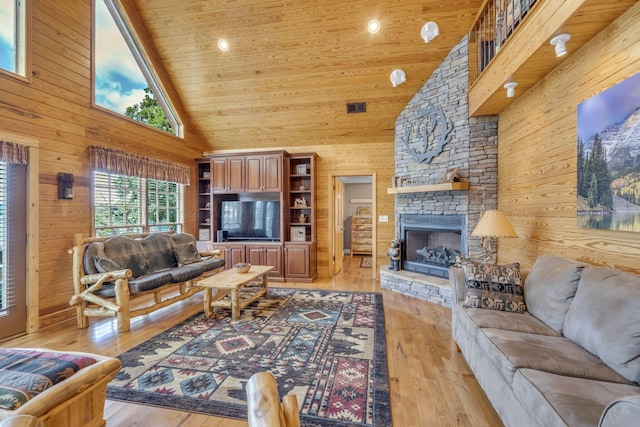 living room featuring wooden walls, high vaulted ceiling, wooden ceiling, and light wood-type flooring