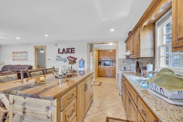 kitchen featuring tasteful backsplash, stainless steel range with electric stovetop, ornamental molding, light tile patterned floors, and butcher block counters