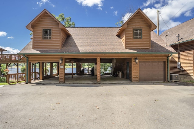 cabin with central AC, a garage, and a carport