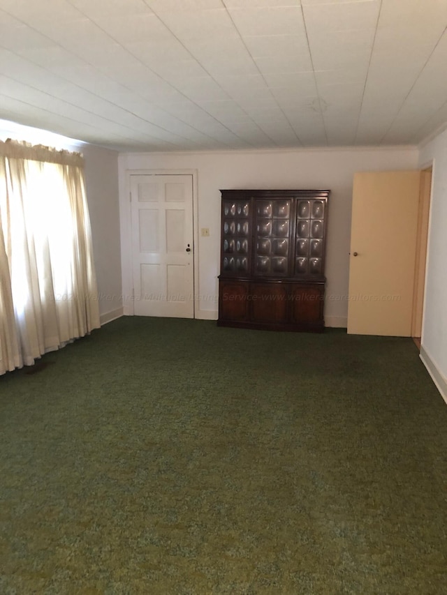 spare room featuring dark colored carpet