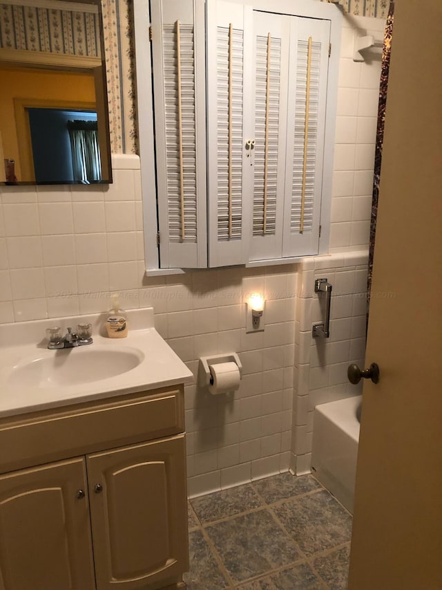 bathroom featuring vanity and tile walls