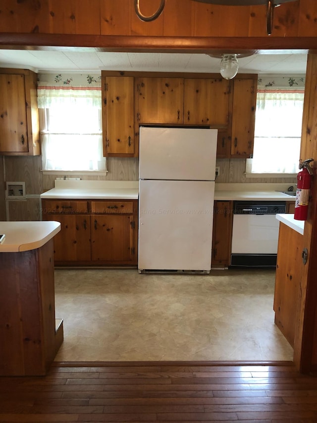 kitchen with white appliances, light hardwood / wood-style floors, and backsplash