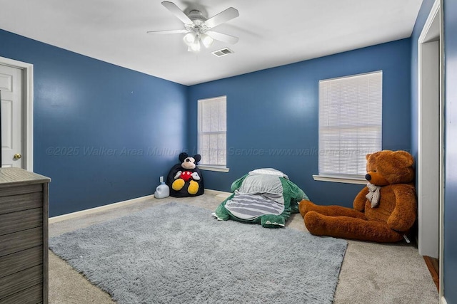 recreation room featuring light carpet, ceiling fan, visible vents, and baseboards