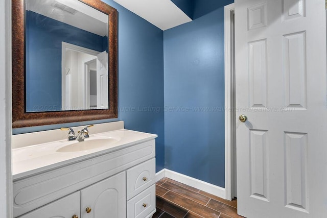 bathroom featuring wood tiled floor, baseboards, and vanity