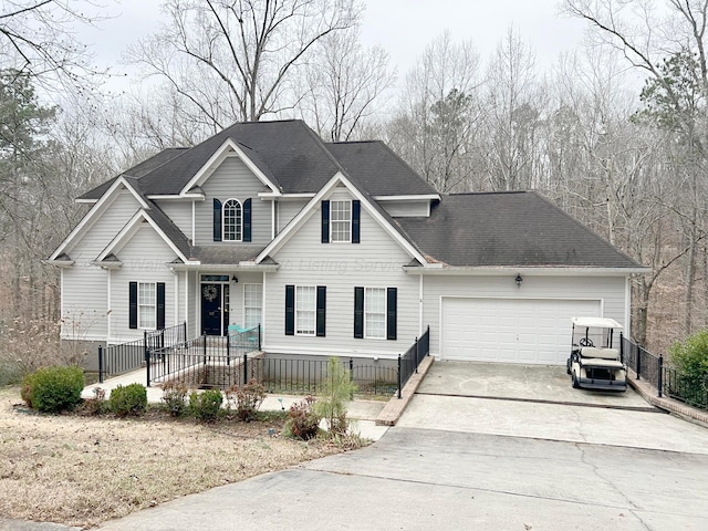 traditional-style house featuring a garage, driveway, and a shingled roof