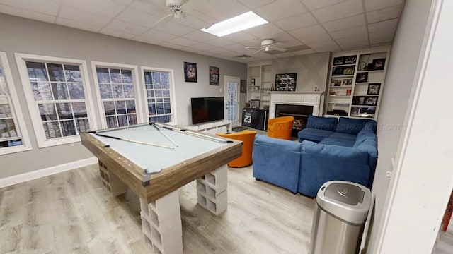 game room featuring billiards, light wood-style flooring, ceiling fan, a paneled ceiling, and a fireplace