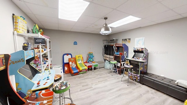 rec room with wood finished floors and a paneled ceiling