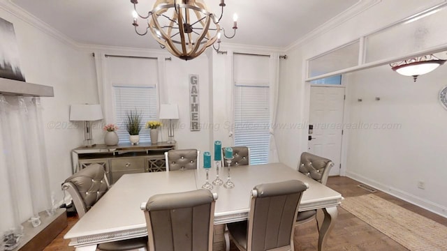 dining area with dark wood-style floors, a chandelier, and crown molding