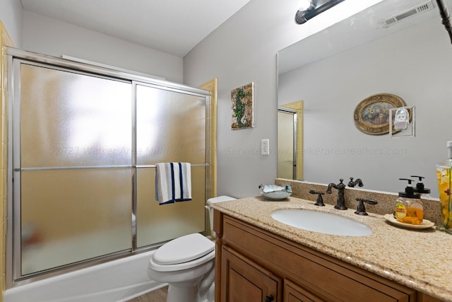 full bathroom featuring shower / bath combination with glass door, vanity, and toilet