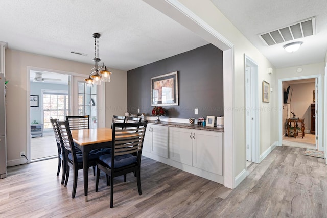 dining area featuring hardwood / wood-style flooring and a textured ceiling