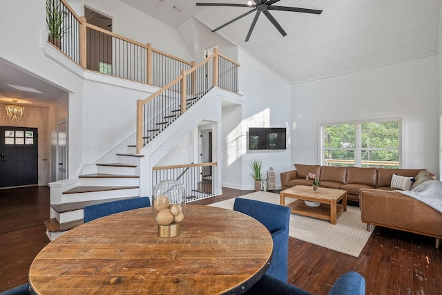 dining space with dark wood-type flooring, ceiling fan with notable chandelier, wood ceiling, and high vaulted ceiling